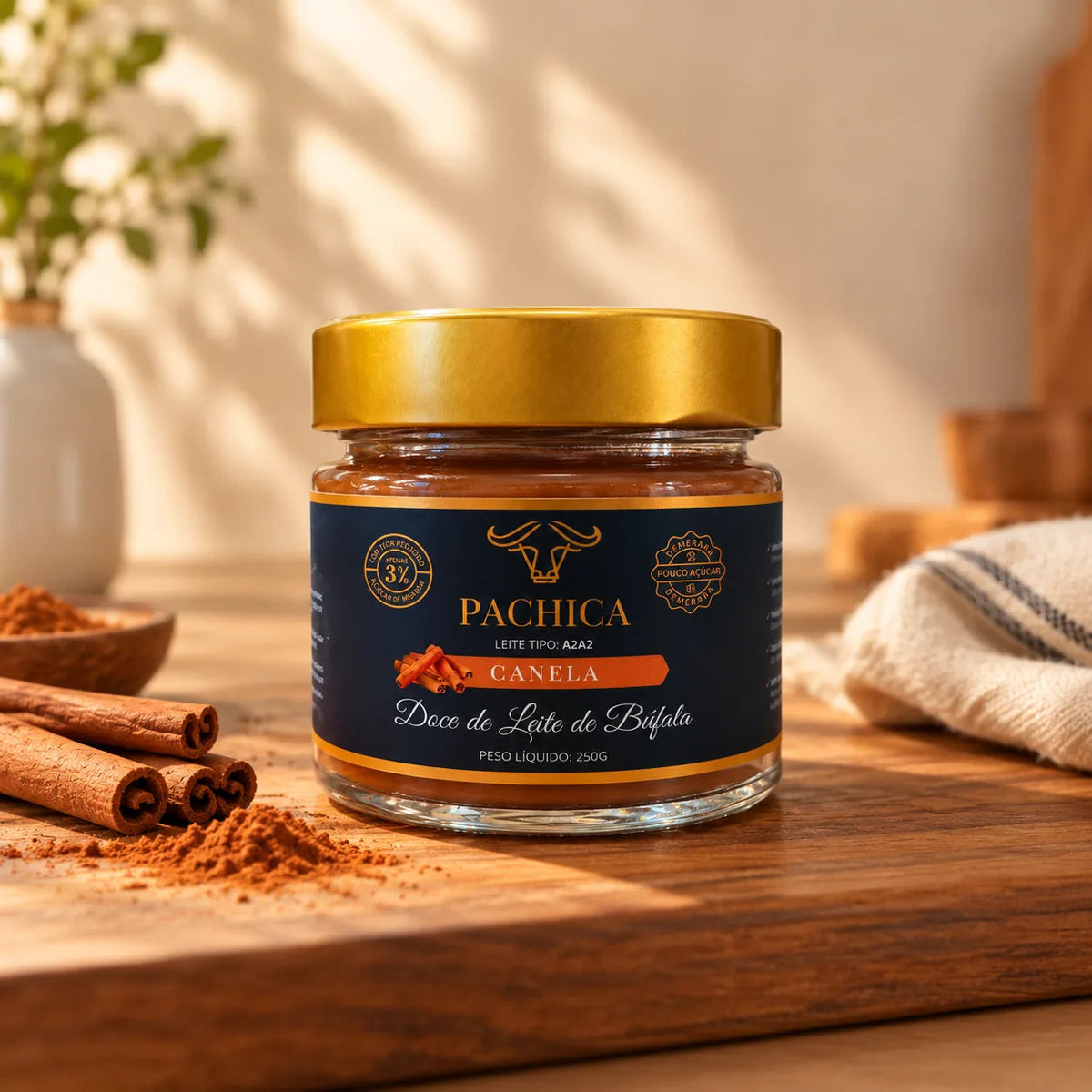 Pote de doce de leite de búfala Pachica Canela, 250 g, sobre tábua de madeira, com canela em pau e em pó